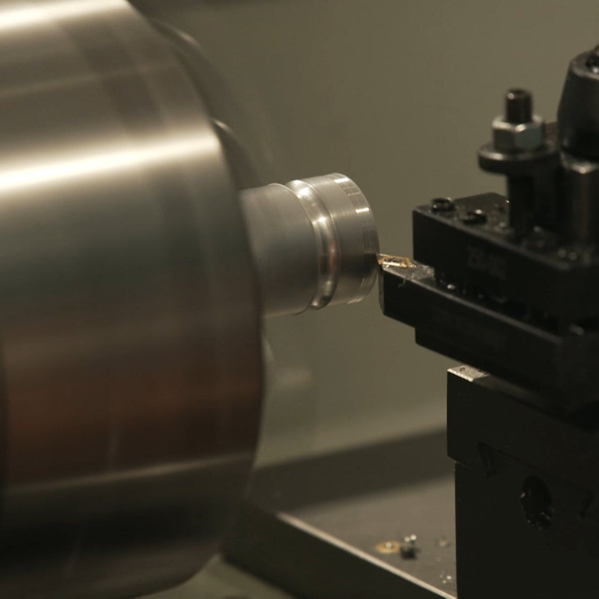 Metal lathe in operation with a metal part being machined.